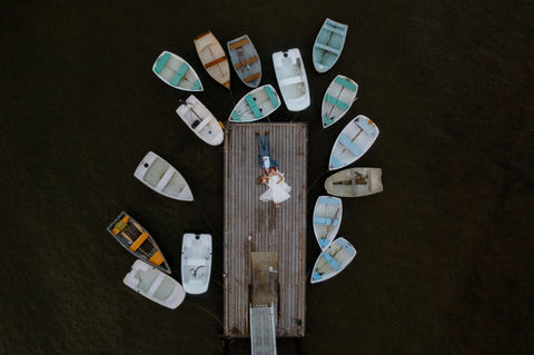 Drone photo of a bride and groom laying on a dock at Peaks Island in Maine