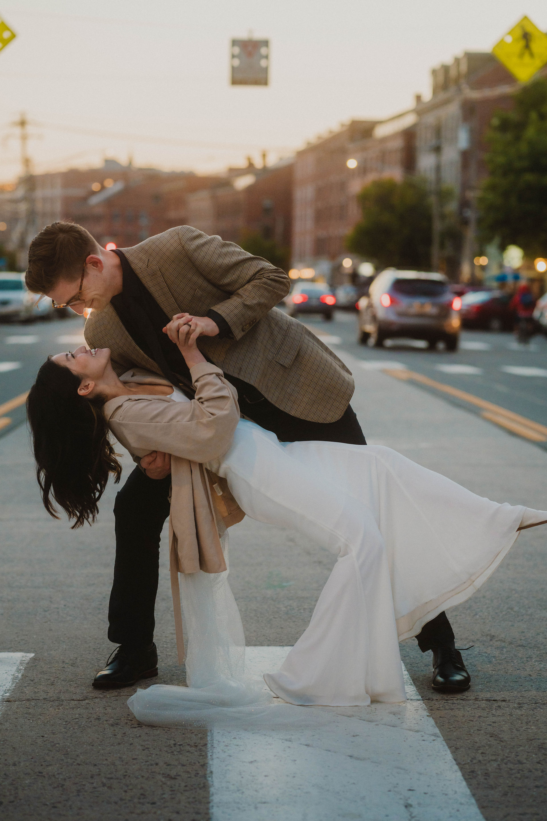 bride and groom dip in the middle of busy street while eloping in Portland, Maine