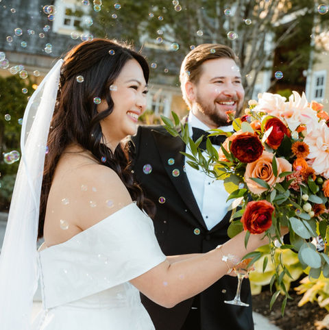 A bride and groom celebrating with bubbles surrounding them immediately after their ceremony at Bedford Village Inn in New Hampshire.