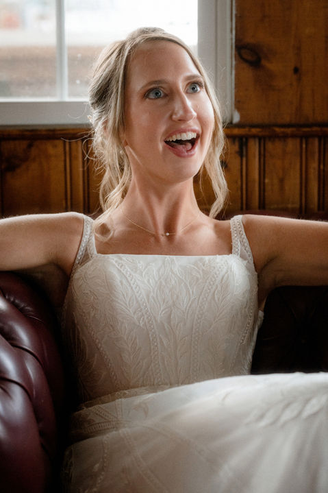 A bride sitting in a chair and smiling in coastal Maine