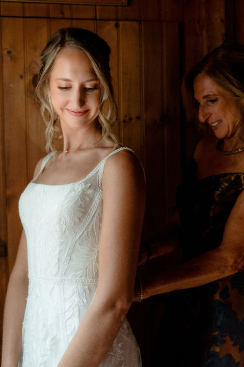A mother helps a bride get into her dress at Peaks Island in Maine