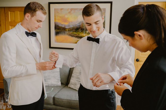 groom putting cufflinks on for his wedding at Autumn Lane Estate in Sebago, Maine