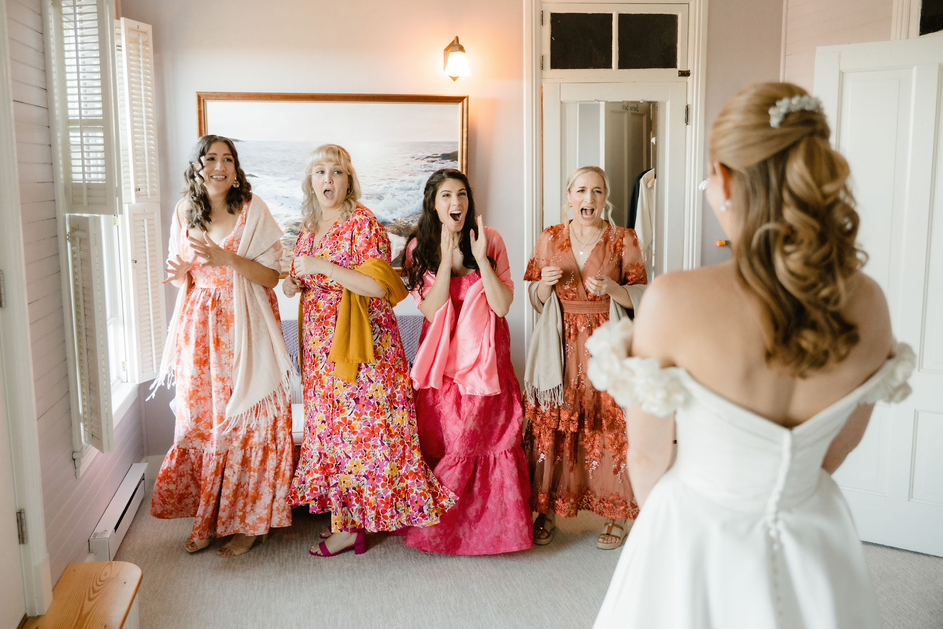 candid wedding photo of the bride sharing a first look with her bridesmaids at grey havens inn in georgetown, maine