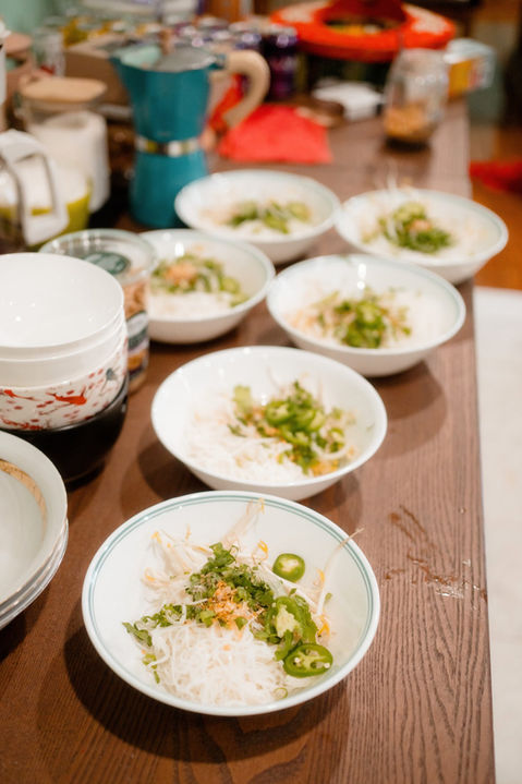 A family dressed in traditional Vietnamese outfits gathered around a table and eating in Connecticut. 