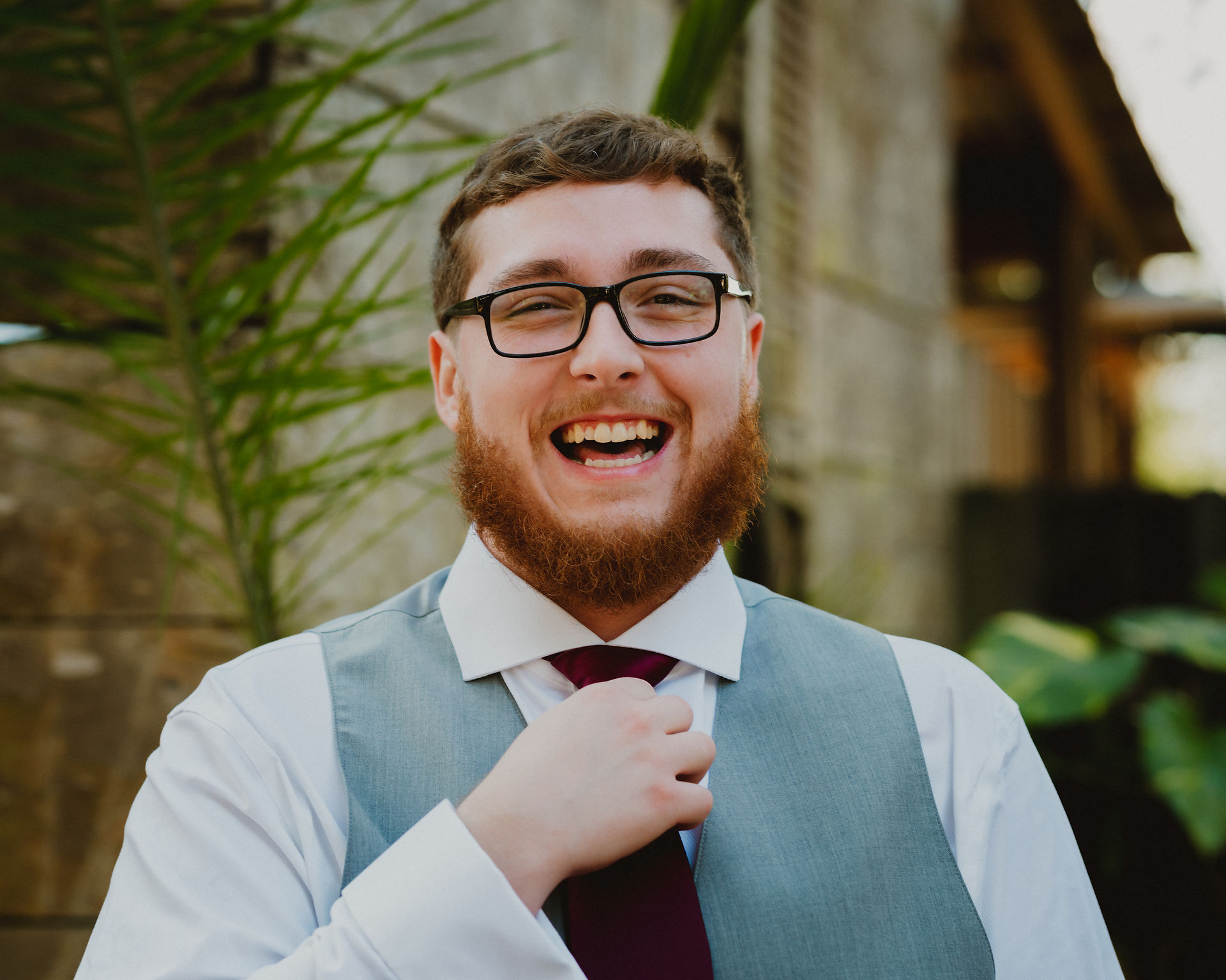 groom fixing his tie and laughing