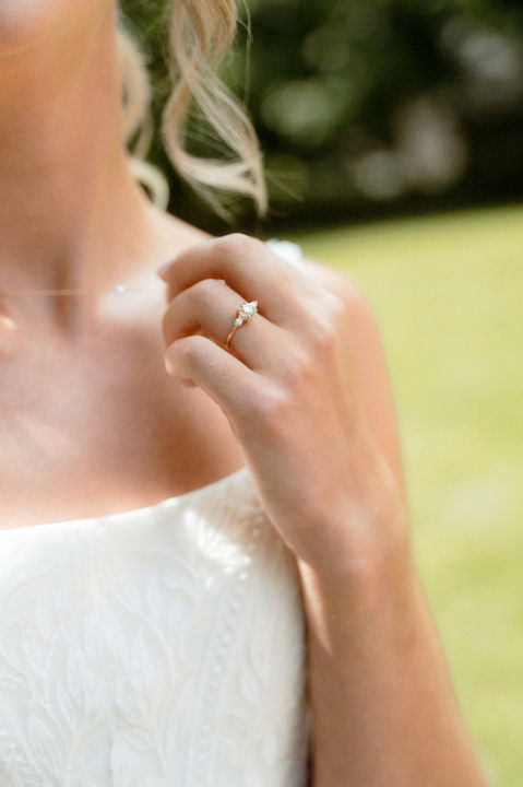 Close up image of a bride holding up her necklace on Peaks Island in Maine