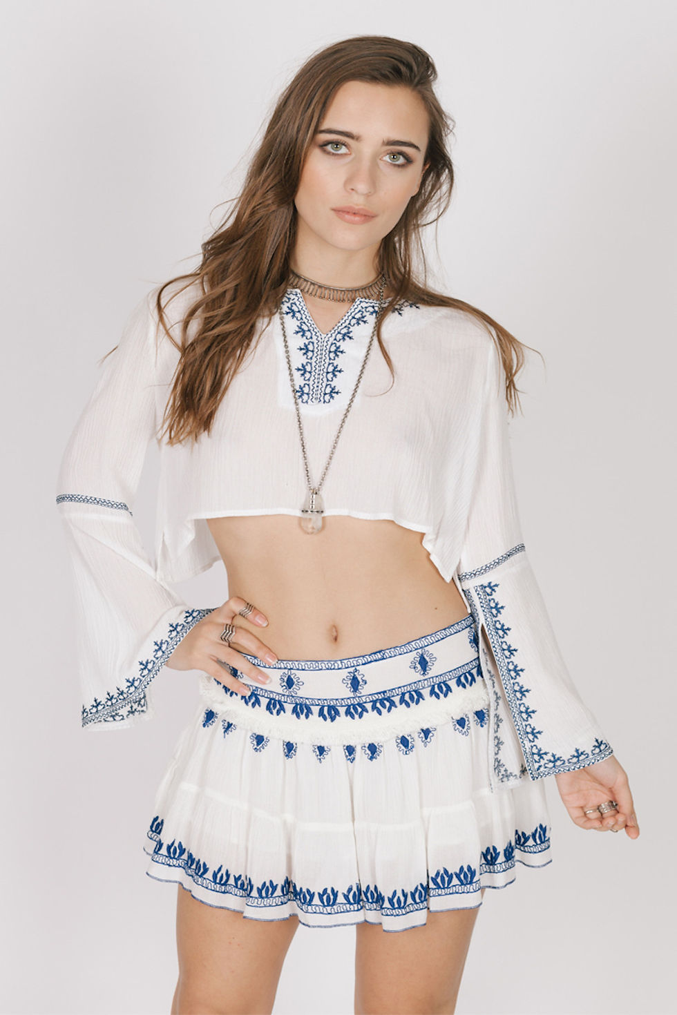 Woman wearing a white blue embroidered Santorini Mini Skirt