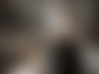 Nora Lum, aka Awkwafina, dressed in a black apron, stands in a busy professional kitchen, looking surprised as she uses a spatula to flip food on a flat-top grill.