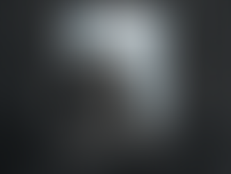 Close-up of actor Judith Light with grey hair and a weary expression, looking through a small reinforced window in a dark metal door.