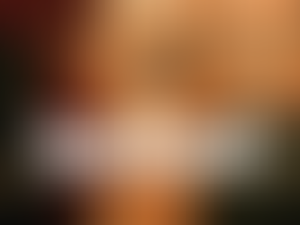 Joe Seanoa as Sweet Tooth, dressed in a distinctive orange and white plaid suit, bow tie, and his signature clown mask, poses dramatically on a stage at a formal party, with a DJ booth and another person in the background.