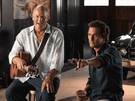 Woody Harrelson holding a guitar and Matthew McConaughey sit in a room with a black vintage car behind them for the show Brothers.
