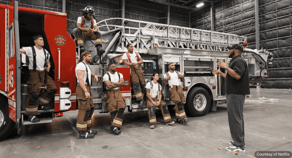 yler Perry directing the cast of Where There’s Smoke next to a fire truck on a Netflix film set.