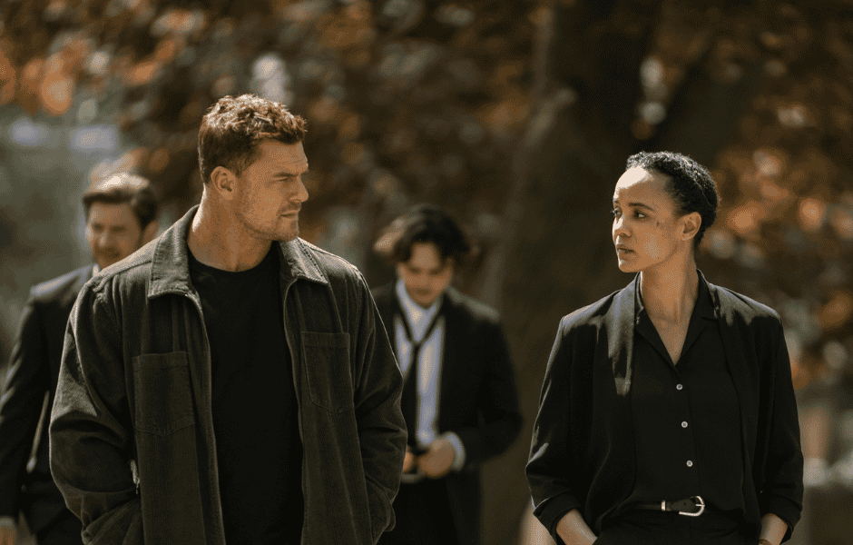 Jasper Jones, Greyston Holt, Alan Ritchson, and Maria Sten walking together outdoors near a tree-lined path.