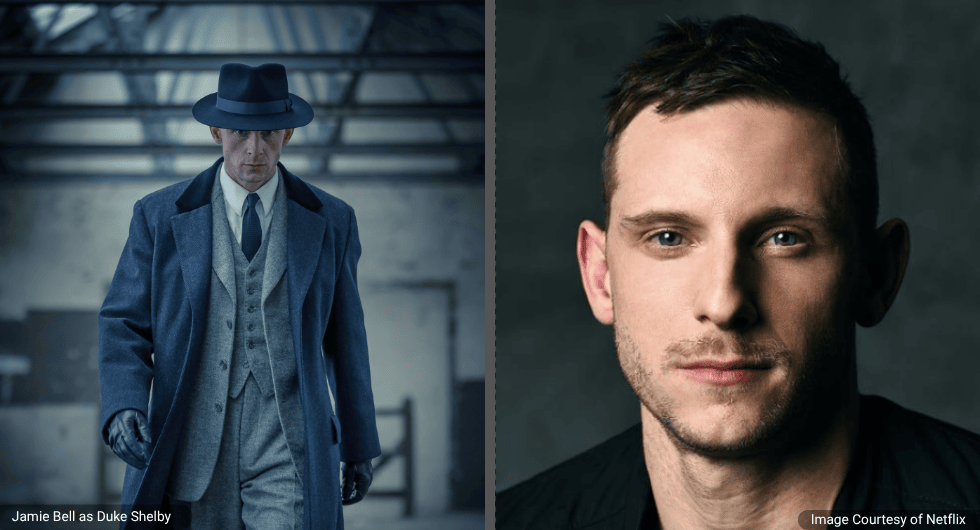Jamie Bell as Duke Shelby in a dark overcoat and fedora, walking through a misty industrial warehouse in the Peaky Blinders spin-off series.