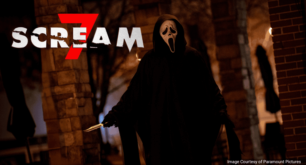 Actor Jeremy Conner as Ghostface in Scream 7 (2026) wearing a black hooded robe and mask while holding a metallic knife in a dark yard.