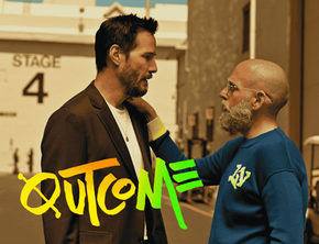 Keanu Reeves stands on a film set while Jonah Hill, in a blue sweater, places a hand on his shoulder. The image has a large Outcome logo in the front.