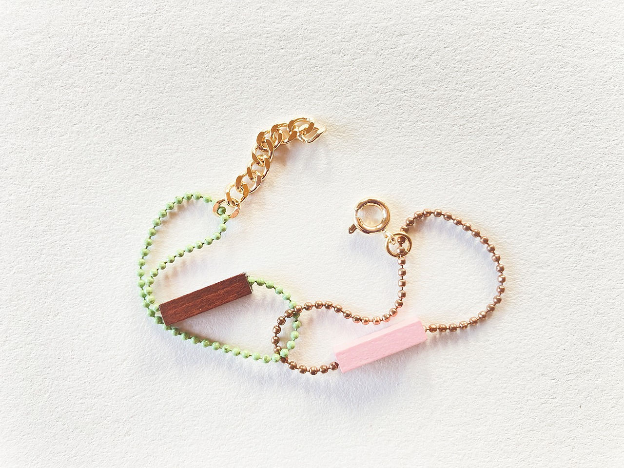 Bracelet enfant en verts-marrons et roses, avec chaîne boule en métal émaillé, perles en bois et fermoir en plaqué or.