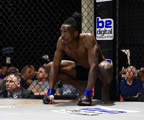 Que Parks crouched in the cage before a fight