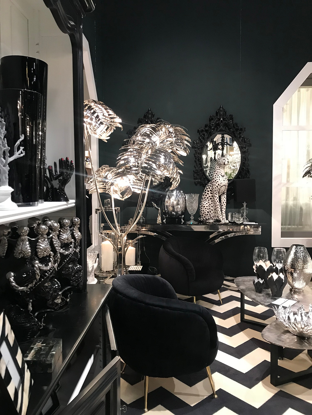 mur sombre, noir dans une ambiance élégante et luxueuse. Palmier de métal argenté.