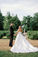 Bride in a strapless satin ballgown and groom in a black tux looking over their shoulders smiling at their Two Rivers Mansion wedding.