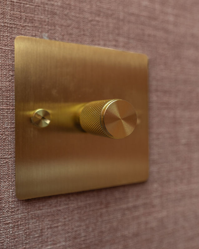 a close up of a brass light switch on a wall