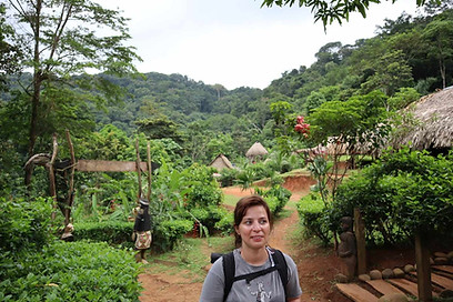 It's a picture of me from my vacation in the Embera Village in Panama. I'm wearing a grey T-shirt and a black backpack, smiling and looking to the left. In the background, there's a jungle with an abundance of green.