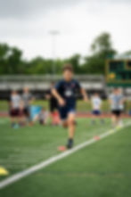 Athlete sprinting on turf during speed and agility training at Division X Training facility.