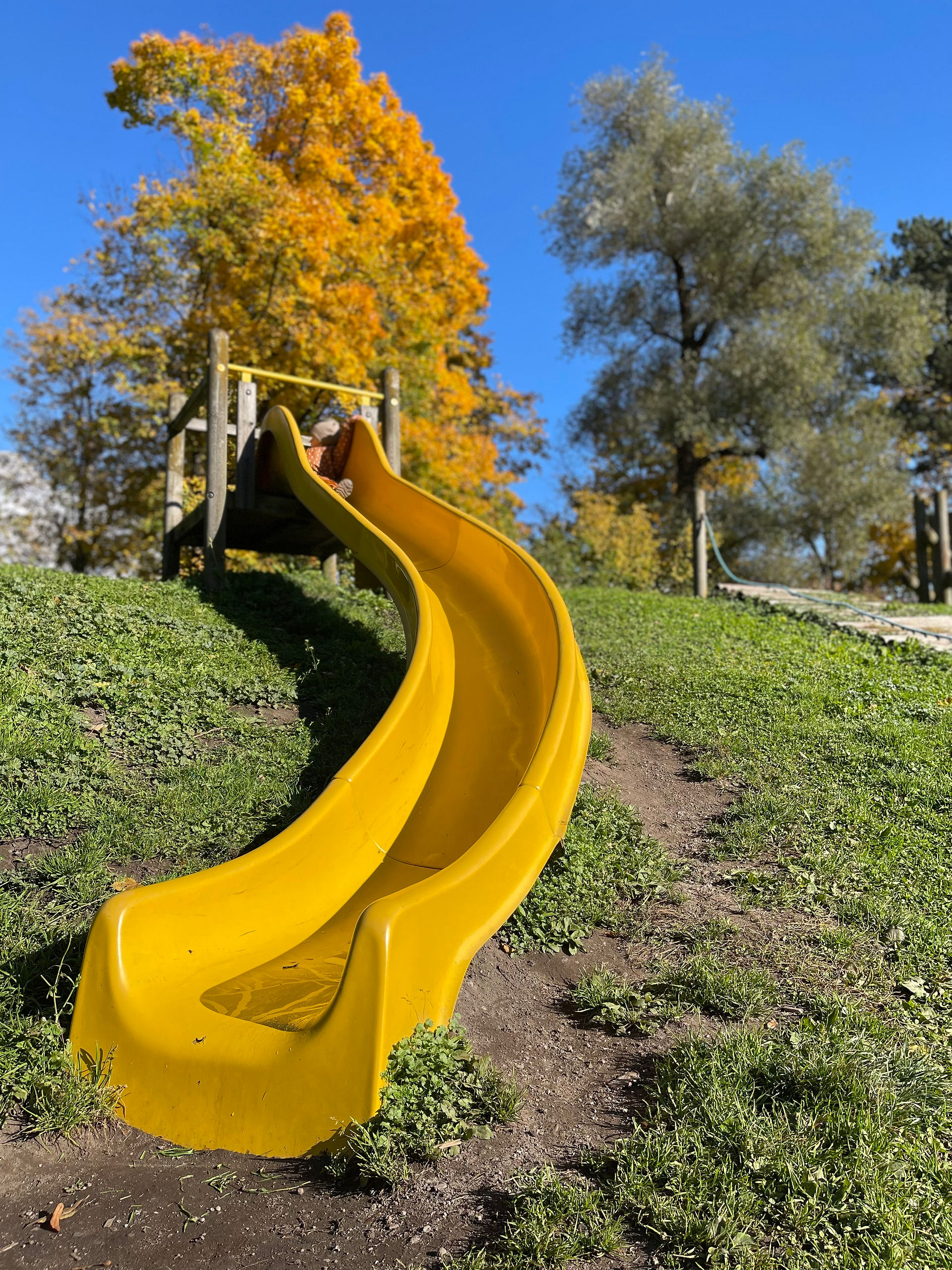 Eine gelbe Rutsche auf einem Spielplatz.