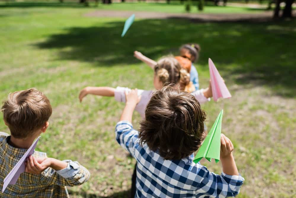 kids throwing paper airplanes