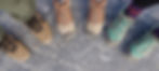 Close up picture of sets of feet, each wearing a different type and color hiking shoe.