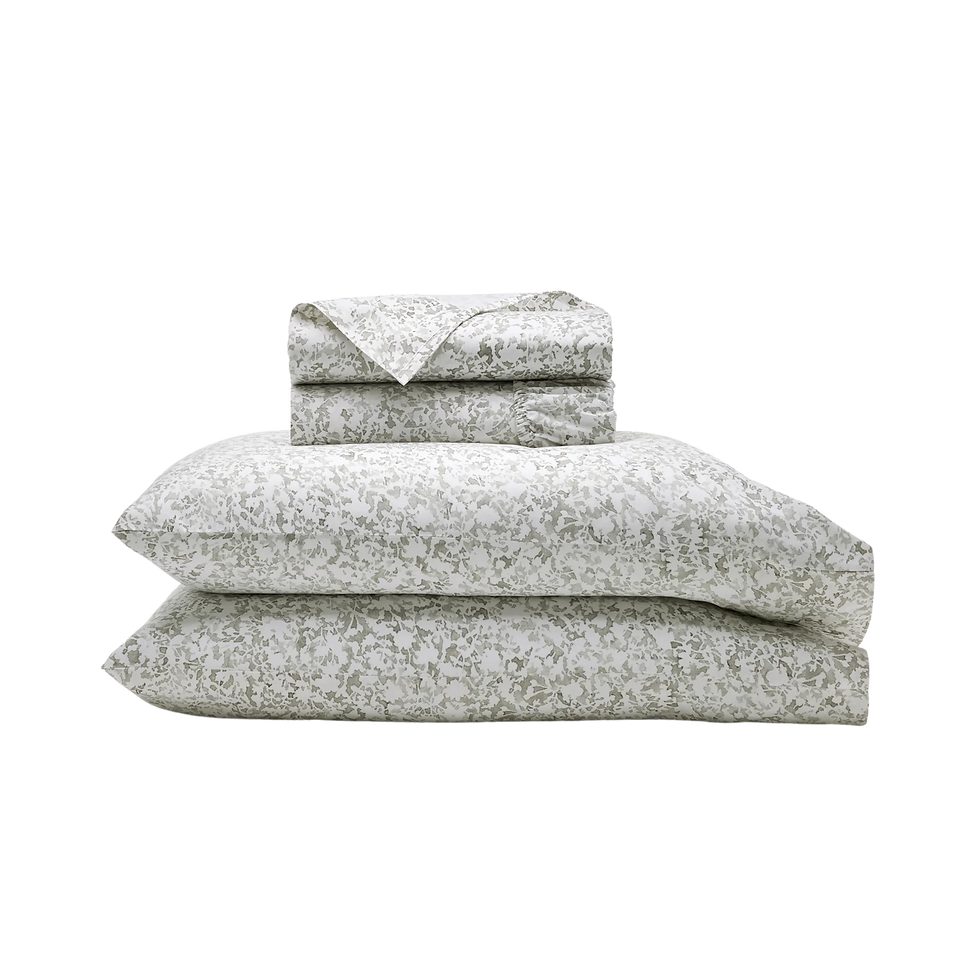 Folded floral-patterned bedding set in light green, including sheets and pillowcases, stacked neatly.