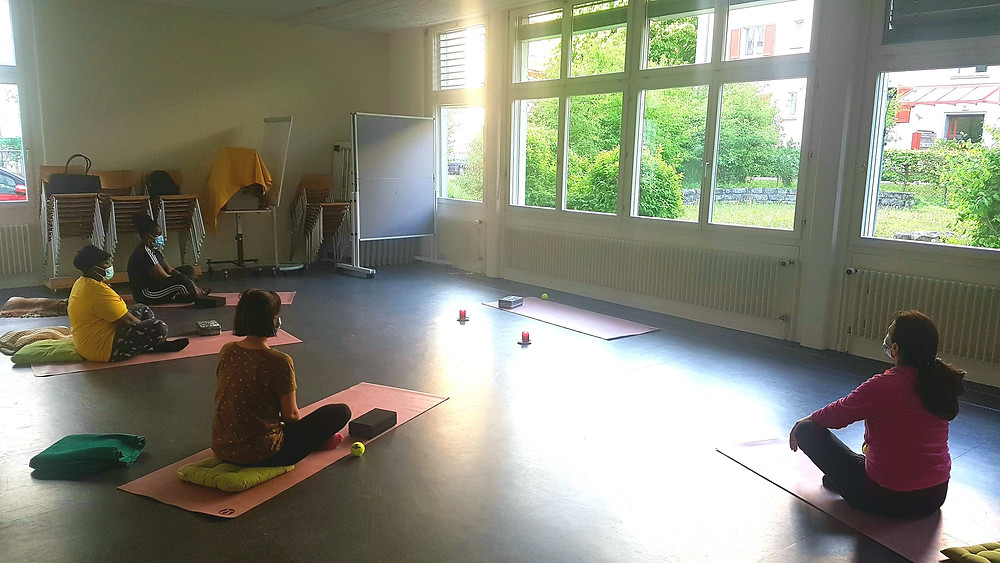 Vier Frauen praktizieren gemeinsam Yoga.