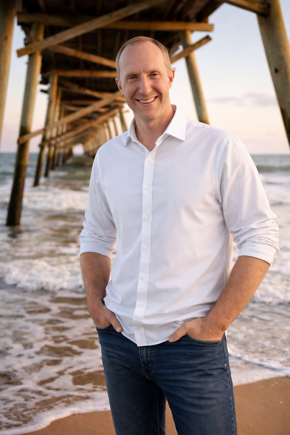 Man at the beach under the pier.png