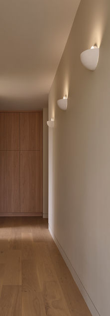 A hallway with sculptural sconce lights