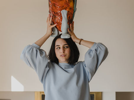 Woman holding vase above her head