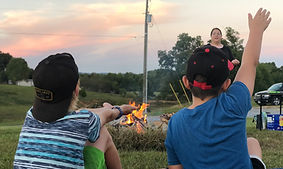 Children raising hands in outdoor service