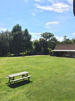 view over swattesfield campsite in suffolk with sunny blue skies