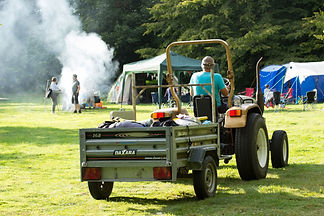 a tractor delivering campers their camping equipment