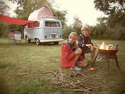 children cooking marshmallows on a fire in front of a VW camper-van at swattesfield campsite
