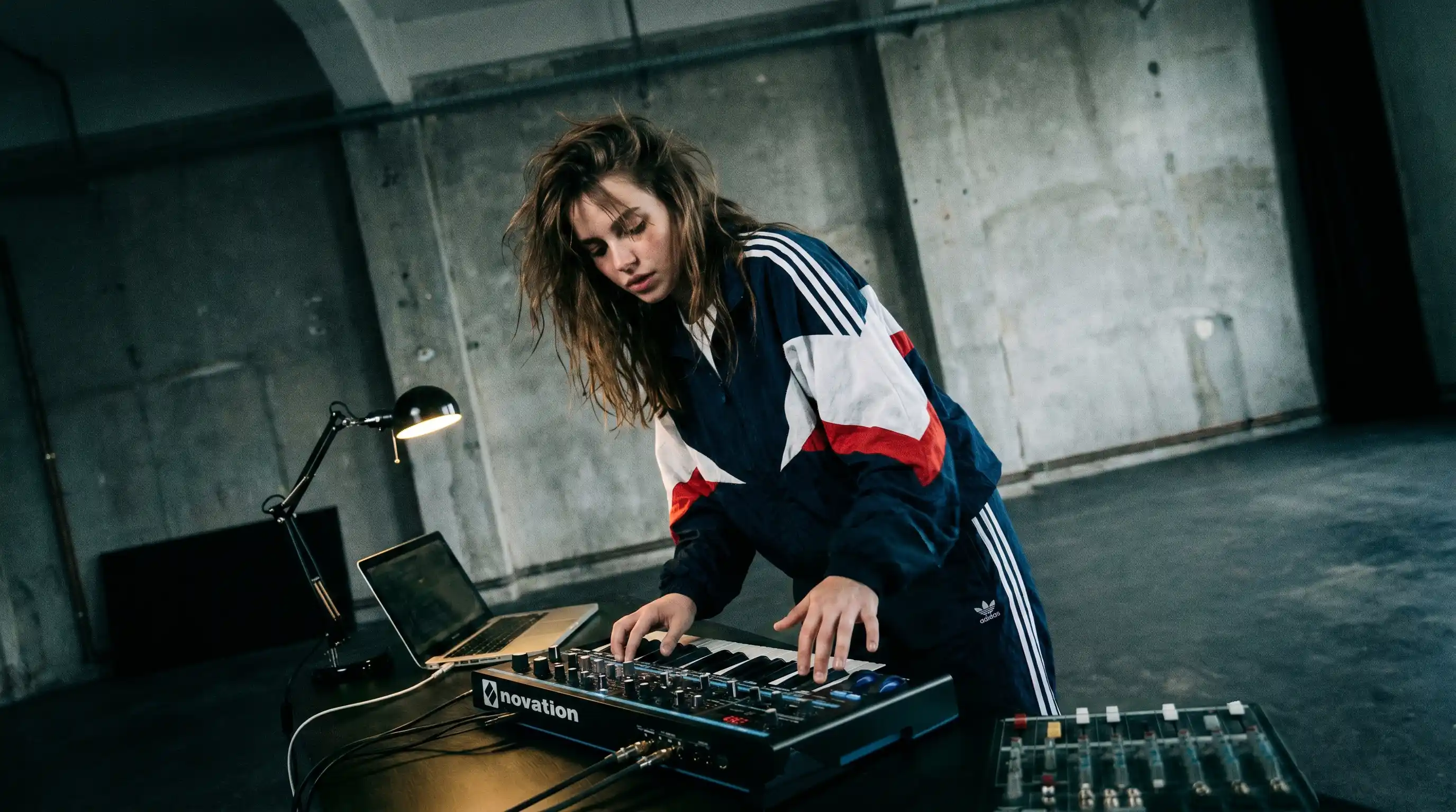 A Power Producer mentee in colourful streetwear performing in a modern industrial performance space with Power Producer.
