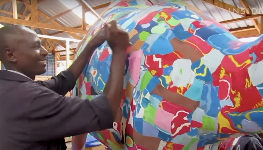 Artist working on a colourful sculpture made from discarded flip flops