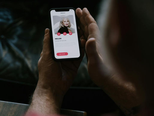 Man looking at a dating app on his iPhone