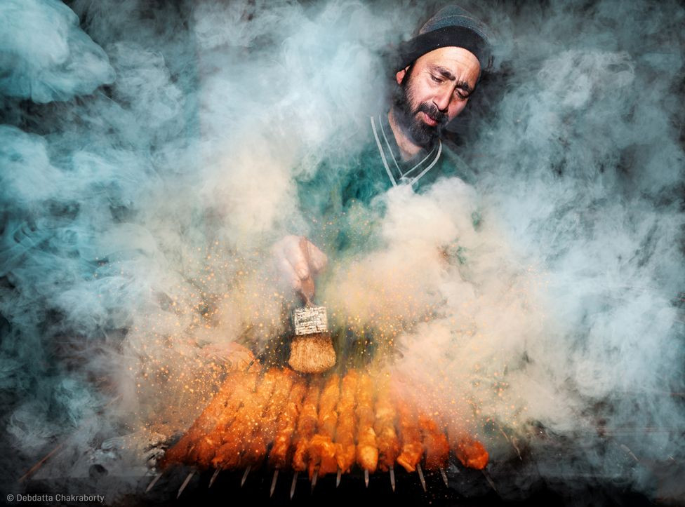 Street vendor preparing wazwan kebabs on his charcoal oven