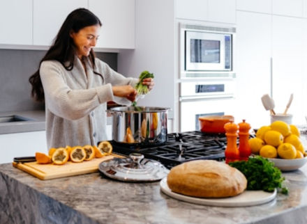 Woman preparing a healthy lunch in her white, modern kitchen