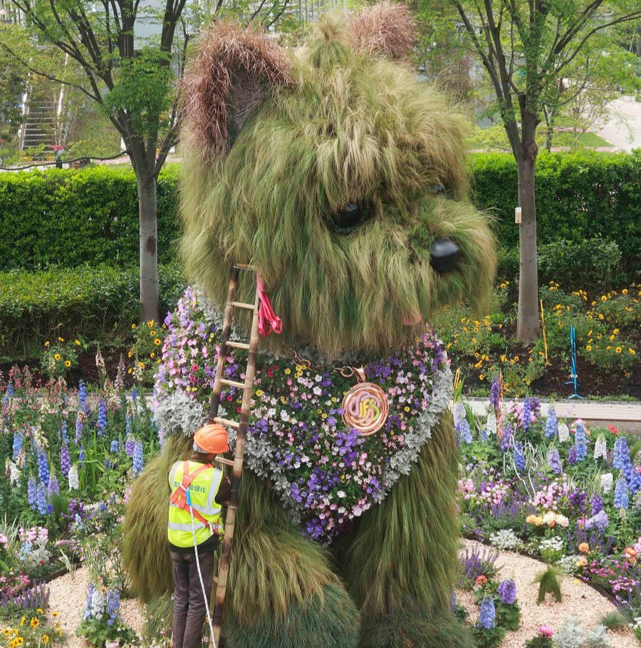 Workers installing a 5.2-meter (17 feet) plant-covered West Highland terrier