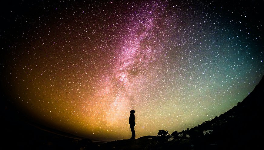 Man staring up at the stars in the night sky