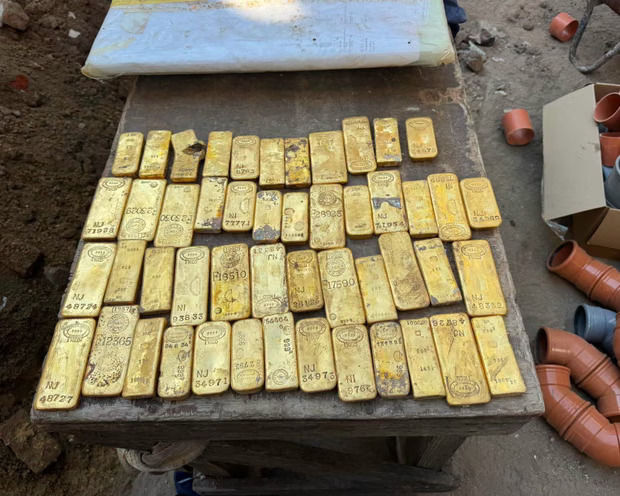 A few dozen gold bars spread out on a table