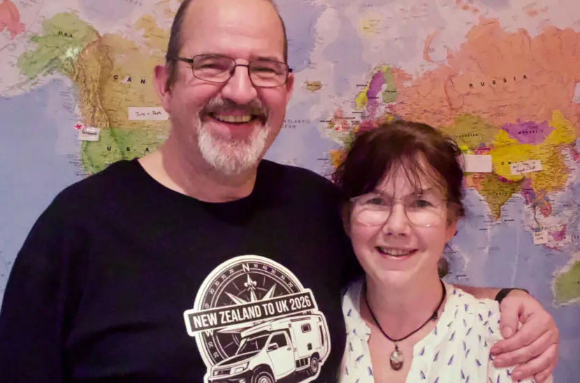 Chris and Marianne Fisher standing in front of a large map of the world