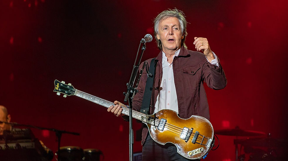 Paul McCartney playing guitar on stage