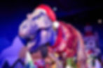 massive animatronic T. rex in a festive sweater and hat